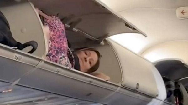 Just plane nuts! Woman naps inside aircraft’s overhead luggage bin